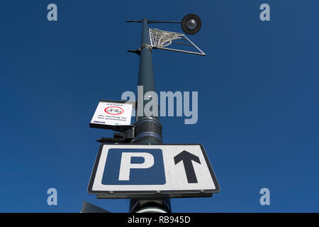 Schild Parkplatz geradeaus und ein Zeichen Warnung Zyklus auf dem Pflaster, im Whitton High Street, Middlesex, England Stockfoto