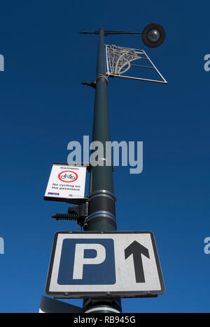 Schild Parkplatz geradeaus und ein Zeichen Warnung Zyklus auf dem Pflaster, im Whitton High Street, Middlesex, England Stockfoto