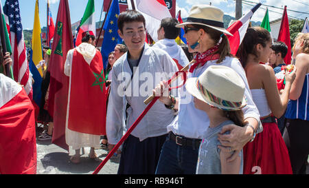 Feiern internationale Studierende für die Kamera posieren auf dem Hintergrund der verschiedenen nationalen Flaggen Stockfoto