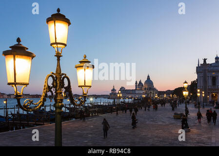 Venedig, Italien, 22. März 2018: die Alten Laternen auf den San Marco Platz mit Santa Maria della Salute im Hintergrund in der Dämmerung in Venedig, Italien Stockfoto