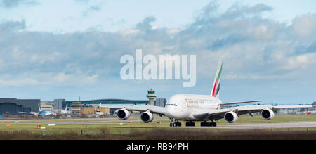 Flughafen Gatwick, England, Großbritannien - 09 Dezember 2018: Ein Airbus A380 der Emirates Airline Taxis nach der Landung am Flughafen London Gatwick. Traffic Control Tower. Stockfoto