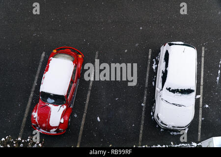 Istanbul, Türkei - Januar 8, 2019: Eine orange Volkswagen Käfer und einem weißen Volkswagen Polo von oben betrachten. Es gibt Schnee auf dem Auto und es zu schneien. Stockfoto