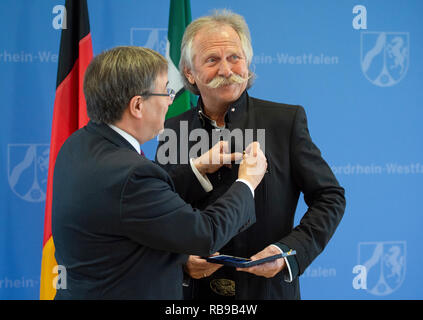 08. Januar 2019, Nordrhein-Westfalen, Düsseldorf: Armin Laschet (CDU, l), Ministerpräsident von Nordrhein-Westfalen, steckt Henning Krautmacher, Sänger der Band Höhner, mit dem Bundesverdienstkreuz. Krautmacher erhält die Medaille für sein soziales Engagement. Foto: Christophe Kirschtorte/dpa Stockfoto
