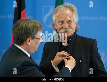 08. Januar 2019, Nordrhein-Westfalen, Düsseldorf: Armin Laschet (CDU, l), Ministerpräsident von Nordrhein-Westfalen, steckt Henning Krautmacher, Sänger der Band Höhner, mit dem Bundesverdienstkreuz. Krautmacher erhält die Medaille für sein soziales Engagement. Foto: Christophe Kirschtorte/dpa Stockfoto