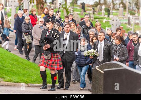 Bantry, West Cork, Irland. Januar 2019. Am 40. Jahrestag der Katastrophe von Whiddy Island, in der der französische Öltanker Betelgeuse 50 tötete, klagt ein einiger Pfeifer als Botschafter Frankreichs in Irland, seine Exzellenz Stephane Crouzat führt die Verwandten zum Denkmal. Verwandte der Toten werden Kränze an der Gedenkstätte legen, bevor sie zu weiteren gedenkfeiern nach Whiddy Island reisen. Credit: AG News/Alamy Live News. Stockfoto