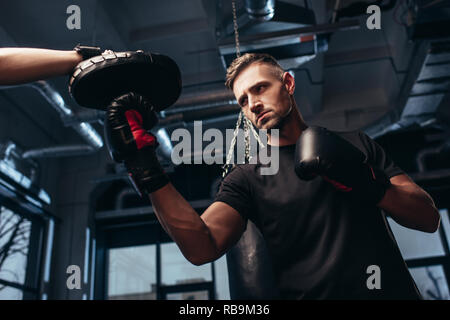Low Angle View von stattlichen Boxer trainieren mit einem Trainer im Fitnessraum Stockfoto