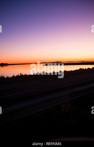 Unglaublich schönen Sonnenuntergang leuchtet Fast unnatürlichen Farben auf einer französischen Salzwassersee im Languedoc Roussillon in Frankreich Stockfoto