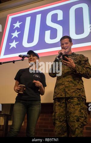 Singer/Songwriter Kellie Pickler Preforms mit einem US-Sailor mit Marine Drehkraft Europa 19,1 (MRF-E) während die 2018 USO Holiday Tour am Vaernes Air Base, Norwegen, Dez. 21, 2018. Seit über 77 Jahren ist die USO hat eine wichtige Verbindung zwischen den Mitgliedern, ihren Familien und dem amerikanischen Volk. Die USO Holiday Tour ist eine Möglichkeit für das Land, seine Anerkennung für seine Truppen zu zeigen. Stockfoto