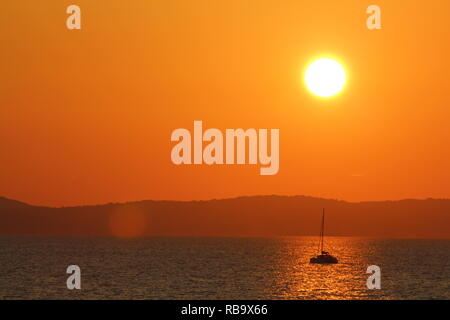 Sonnenuntergang zwischen Split und Brac in Kroatien. Sonne, die in der Adria geht, auf einem Segelboot, tolle Aussicht. Stockfoto