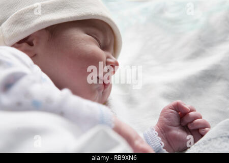 Neugeborene schlafen auf der Seite positionieren. Paar Stunden altes Baby im Krankenhaus Krippe Stockfoto