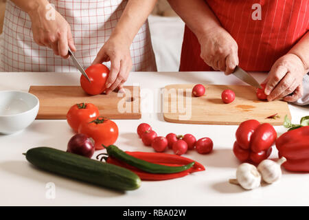 Eine erwachsene Tochter und eine ältere Mutter zusammen kochen zu Hause in der Küche. Gesunde frische Lebensmittel. Stockfoto