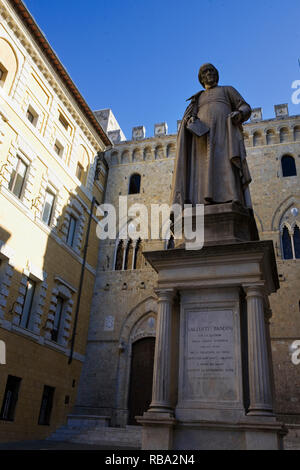 Die Statue von Sallustio Bandini von Tito Sarrocchi in der Piazza Salimbeni, mit dem Palazzo Spannocchi jenseits: Contrada del Drago, Siena, Toskana, Italien Stockfoto