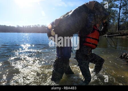 Armee Kapitän Rob Killian, Recht, mit der Colorado Army National Guard B-Company, 5 Bataillon, 19 Special Forces Group (Airborne), und sein Mannschaftskamerad Rucksack ein Floß zu Ihren Schultern heben, wie sie die Ausfahrt Kings Teich in Fort Benning, Georgia, während Ausbildung in diesem Jahr Generalleutnant David Grange besten Ranger Wettbewerb, Mittwoch, Januar 25, 2017 zu konkurrieren. Killian, zusammen mit Mannschaftskameraden Army Staff Sgt. Erich Friedlein gewann den Wettbewerb des letzten Jahres, das erste mal in der 34-jährigen Geschichte des Wettbewerbs ein Team aus der Armee nahm den ersten Platz. Stockfoto