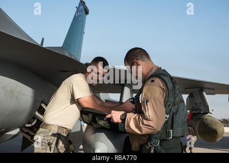 Staff Sgt. Larry Runk, 407 Expeditionary Maintenance Squadron Mannschaft Leiter, (links) spricht mit einem Piloten, der 134 Expeditionary Fighter Squadron während des Preflight Checks am 407 Air Expeditionary Gruppe, Dez. 29, 2016 zugeordnet. Beide Piloten sind von den 158 Fighter Wing, die Teil der Vermont Air National Guard eingesetzt. Stockfoto