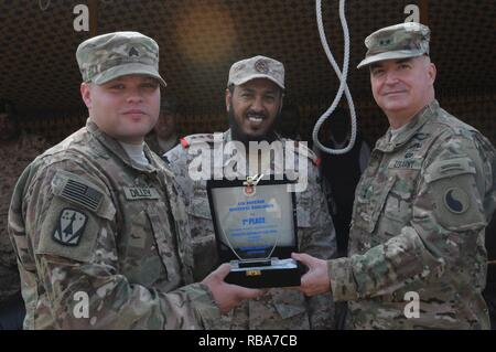 Sgt. Brian Dilley, einem truppführer mit der 69Th Air Defense Artillery Brigade, nimmt den ersten Platz Preis im Namen seiner Einheit von Major General Blake Ortner, Kommandant der 29 Infanterie Division und Oberst Jabar Al-boti des kuwaitischen Air Defence Force während der Patriot Tag Aktivitäten auf Kuwait Air Defence Force Headquarters in Kuwait 28. Dezember 2016. Der Wettbewerb zwischen den Kuwaitis und die 69 ADA enthalten Ereignisse wie z. B. Einrichten einer MIM-104 Patriot-Waffensystem, ein Fußball-Spiel, und Tauziehen. ( Stockfoto