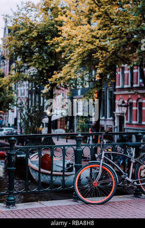 Mit dem Fahrrad auf einer Brücke in Amsterdam, Niederlande, geparkt. Typische Stadtbild Stockfoto
