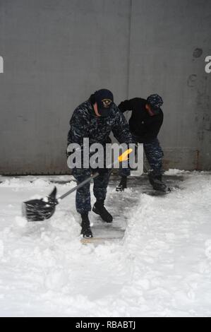 Der Luftfahrt Bootsmann Mate (Start und Wiederherstellung) Airman Zachery Pavey schaufeln Schnee an Bord der Flugzeugträger USS George Washington (CVN 73) im Winter Storm Helena. Das Schiff ist in Norfolk homeported Vorbereitung nach Newport News, Virginia für die Betankung komplex (RCOH) Wartung zu bewegen. Stockfoto