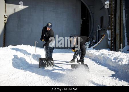 NORFOLK (Jan. 8, 2017) Fachkraft für Lagerlogistik 3. Klasse Ileana Marrero Rivera, Links, und der Luftfahrt Bootsmann Mate (Handling) Airman Matcus Brawner arbeit Eis von Wintersturm Helena zu entfernen an Bord der Flugzeugträger USS George Washington (CVN 73). George Washington ist in Norfolk homeported Vorbereitung nach Newport News, Virginia für die Betankung komplexe Überholung (RCOH) Wartung zu bewegen. Stockfoto