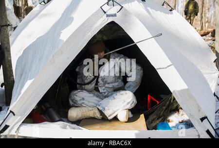 Lance Cpl. David W. Smith, rifleman, Unternehmen I, 3.Bataillon, 25 Marine Regiment, 4 Marine Division, mans ein Radio während der Übung Nordic Frost im Camp Ethan Allen Training Website in Jericho, Vt, Jan. 6. 2017. Während der gesamten Übung, Marines Durchführen der Schulung in einem anspruchsvollen Umfeld zu schaffen, das bei kaltem Wetter stellen ein Augenmerk auf kleine Einheit Führung. Stockfoto