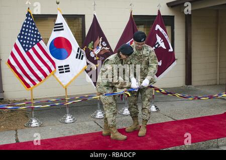 YONGSAN GARNISON, Südkorea - Col. Wendy Harter, Kommandant der 65. medizinische Brigade, U.S. Army Medical Department Aktivität - Korea, und Oberst Jae Hwang, der Kommandant der 618 . Dental Gmbh (Bereich Unterstützung), zahnmedizinische Gesundheit Aktivität - Korea, schneiden Sie den Ribbon Controller während der Eröffnungsfeier für die Dental Wellness Center der US-Armee Garnison Yongsan, Südkorea, Jan 9. Die Zahnmedizinische Wellnesscenter war ursprünglich der Carius Zahnklinik, Gedenken an Hingabe und Aufopferung von Maj. Marvin Carius, ein Zahnarzt, der in der Aktion während des koreanischen Krieges getötet wurde, benannt. Derzeit, Marvin's Enkel, Kapitän Br Stockfoto