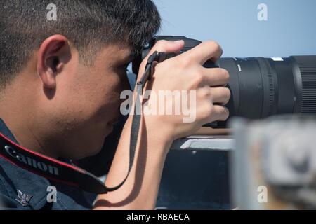 Intelligence Specialist 3. Klasse Zachary Cervantez, aus Santa Clara, Kalifornien, sammelt visuelle Informationen an Bord der geführte Anti-raketen-Zerstörer USS Chung-Hoon (DDG93) im Golf von Aden, Dez. 16, 2018. Chung-Hoon ist in die USA 5 Flotte Bereich der Maßnahmen zur Unterstützung der Marine im Einsatz für die Stabilität und Sicherheit in der Region zu gewährleisten und verbindet das Mittelmeer und den Pazifischen Raum durch den westlichen Indischen Ozean und drei strategischen Punkten ersticken. Stockfoto