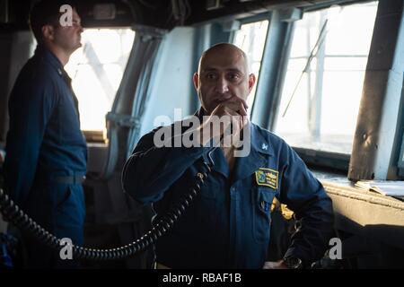 Us-Marine Kapitän Murz Morris, Commodore, Destroyer Squadron (DESRON) 21, auf die Mannschaft über den Hauptstromkreis spricht an Bord der geführte Anti-raketen-Zerstörer USS Decatur (DDG73) im Arabischen Meer, Dez. 17, 2018. Die John C Stennis Carrier Strike Group ist in die USA 5 Flotte Bereich der Maßnahmen zur Unterstützung der Marine im Einsatz für die Stabilität und Sicherheit in der Region zu gewährleisten und verbindet das Mittelmeer und den Pazifischen Raum durch den westlichen Indischen Ozean und drei strategischen Punkten ersticken. Stockfoto