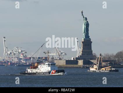 Coast Guard Cutter Penobscot Bay, einem 140-Fuß-inländischen Icebreaker in Bayonne, New Jersey homeported, Transite der Upper New York Hafen in der Nähe der Freiheitsstatue am ersten Tag Eis brechende Saison Montag, 04.12., 17., 2018. Eis der Küstenwache brechen, unter Betrieb zuverlässig Energie durchgeführt für Nordosten Wintern (OpRENEW), sollen sicherstellen Nordosten Gemeinschaften haben die Sicherheit, Energie und Ressourcen, die Sie benötigen den ganzen Winter. Stockfoto