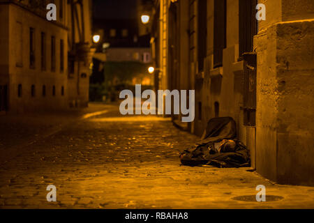 Paris, Frankreich, 12. Mai 2017: Eine obdachlose Person schlafen in einer dunklen Gasse in den Straßen von Paris. Stockfoto