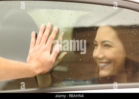 Glückliche Paare oder Freunde Abschied Berühren Hände durch ein Auto, Fenster, bevor Sie reisen Stockfoto