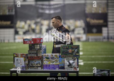 Staff Sgt. Mario Acevedo, ein Training Chief mit G-3/5-, Force Headquarters Group, Marine Reserve, restocks eine Tabelle mit Spielzeug bei einem Spielzeug für Kleinkinder bei den New Orleans Saints Schulungszentrum in Metairie, La., Dez. 20, 2018. Lokale Spielzeugsammlung Kampagnen beginnen im Oktober und dauert bis Mitte bis Ende Dezember. Mitglieder der Gemeinschaft neue, ausgepackten Spielwaren in Sammelboxen in lokalen Unternehmen positioniert. Stockfoto
