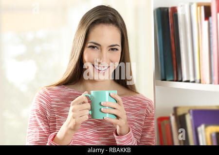 Vorderansicht Porträt einer Frau hält eine Tasse Kaffee mit Kamera Stockfoto