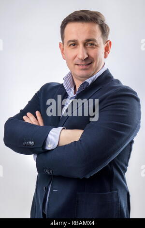 Porträt von einem gutaussehenden Jungen im mittleren Alter CEO in einem blauen Anzug und lächelnd Stockfoto