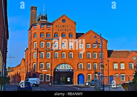 Blick auf die Straße des berühmten devizes Brauerei Wadworth & belegten Gebäude von 1875 gegründet. Markanten roten Backsteinmauern gegen einen klaren blauen Himmel. Stockfoto