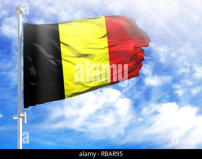 Flagge von Belgien auf einen Fahnenmast vor blauem Himmel. Stockfoto