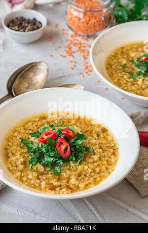 Hausgemachte Linsensuppe in Schalen auf grauem Beton Hintergrund. Gesunde vegetarische Nahrung. Selektive konzentrieren. Stockfoto