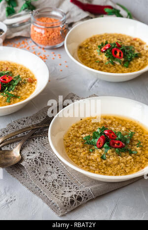 Hausgemachte Linsensuppe in Schalen auf grauem Beton Hintergrund. Gesunde vegetarische Nahrung. Stockfoto