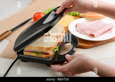 Mann mit einem panini drücken Sie Stockfoto