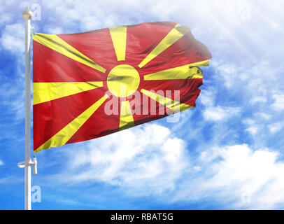 Nationalflagge von Mazedonien auf einem Fahnenmast vor blauem Himmel. Stockfoto