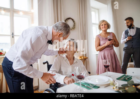 Eine alte Großmutter in einem Rollstuhl feiert Geburtstag mit Familie, eine party Konzept. Stockfoto