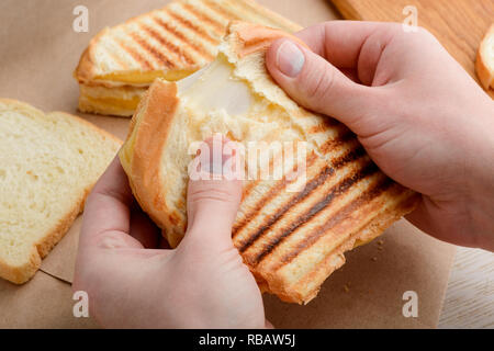 Händen reißen ein Sandwich Stockfoto