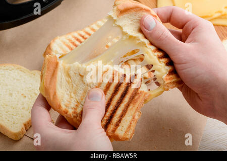 Händen reißen ein Sandwich Stockfoto