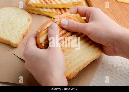 Hände halten einen sandwich Stockfoto