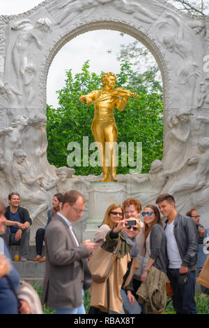 Touristen Wien, Blick auf eine Gruppe von Touristen eine selfie Foto vor dem Goldenen Strauss Statue in der Statdtpark in Wien, Wien, Österreich. Stockfoto