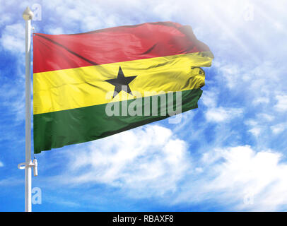 Nationalflagge von Ghana an einem Fahnenmast vor blauem Himmel. Stockfoto
