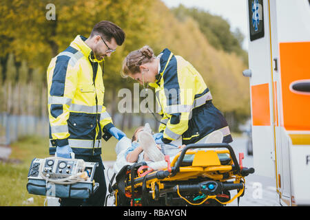 Not-Arzt, der Sauerstoff an Unfallopfer Stockfoto