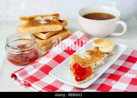 Heart-shaped Toast mit Marmelade und Tee Stockfoto