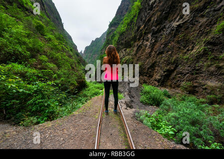 Junge Frau stand am Rande eines verlassenen Minen Eisenbahn, im tropischen Dschungel auf Teneriffa, Kanarische Inseln, Spanien. Stockfoto