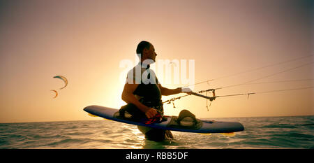 Silhouette der Kite Surfer im Stehen in Wasser Stockfoto