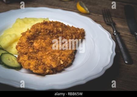 Huhn gebratenes Schnitzel mit Kartoffelbrei und Zitrone auf Holz Tisch Stockfoto