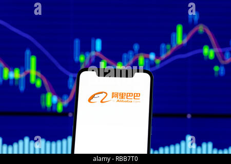 Alibaba Logo ist auf einem Smartphone über Stock chart Stockfoto